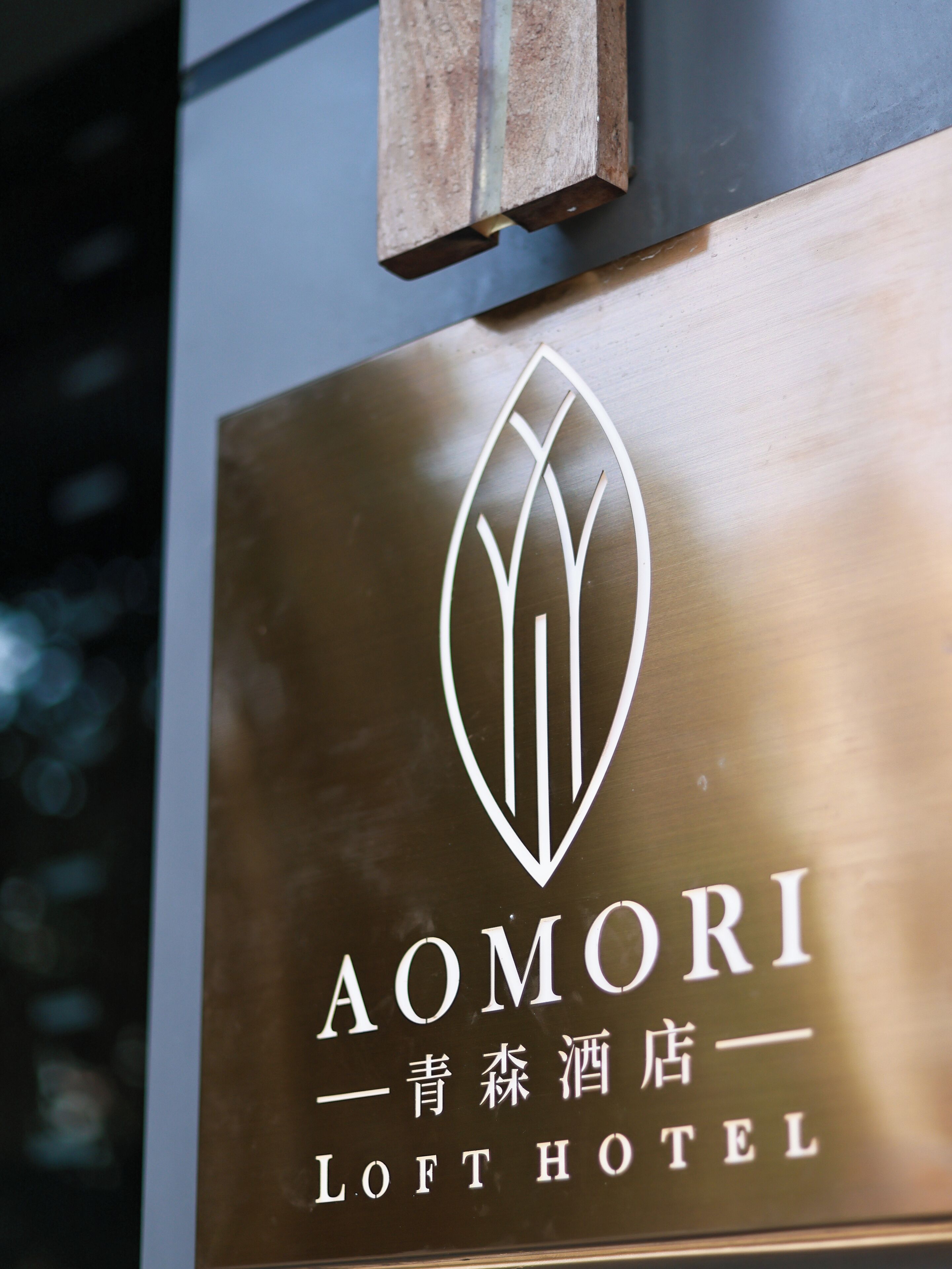 A hotel sign with a logo and name "AOMORI LOFT HOTEL".