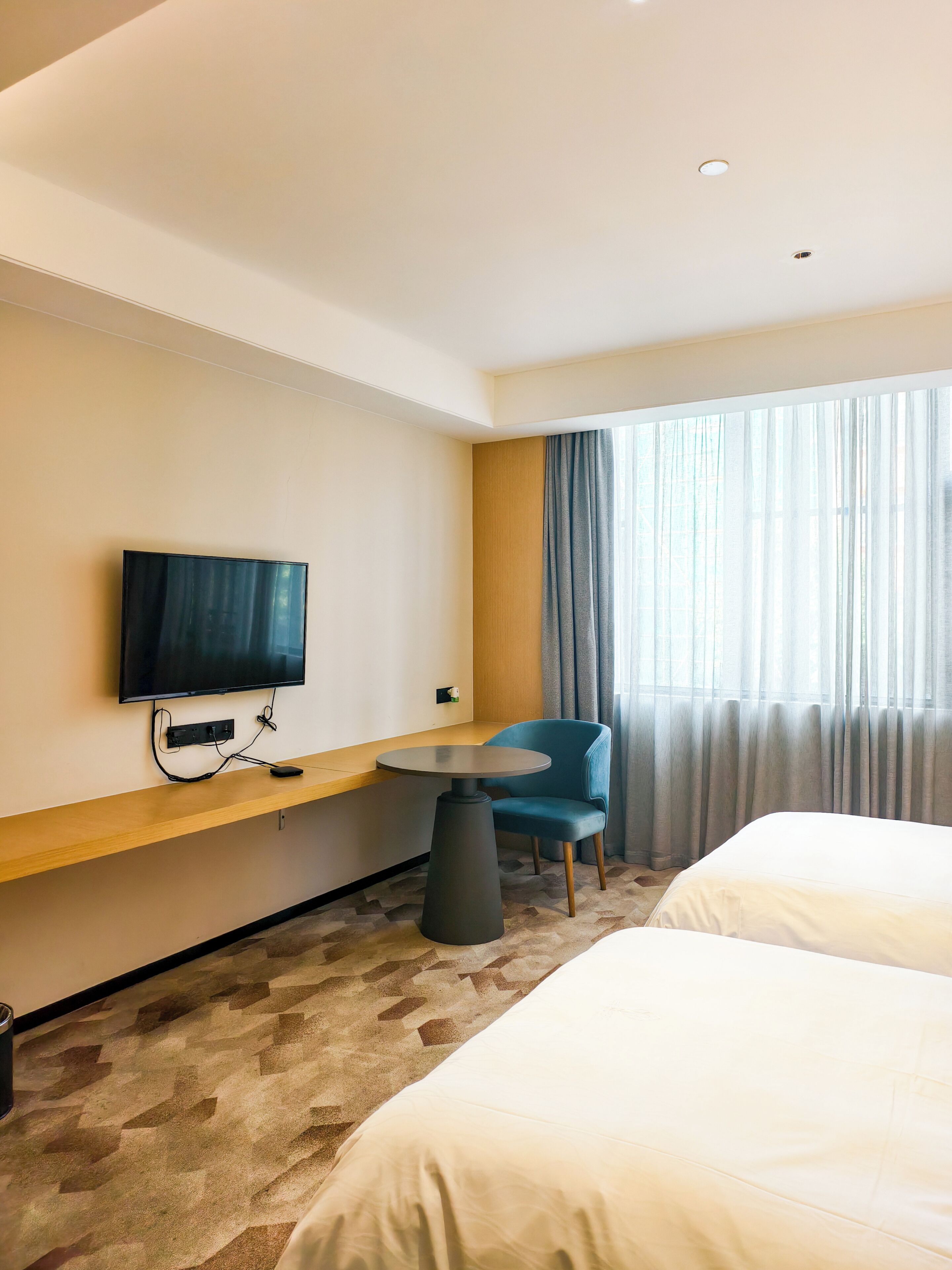 Une chambre d’hôtel avec un lit, une télévision, un bureau et une chaise.