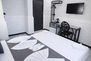 A hotel room with a bed, a chair, a TV, and a small table with a kettle. - D Twins plus Hotel (Arnavutköy)