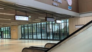 Un espace intérieur avec un panneau indiquant « Istanbul Havalimanı », un escalier mécanique et un panneau signalant l’accès au métro.