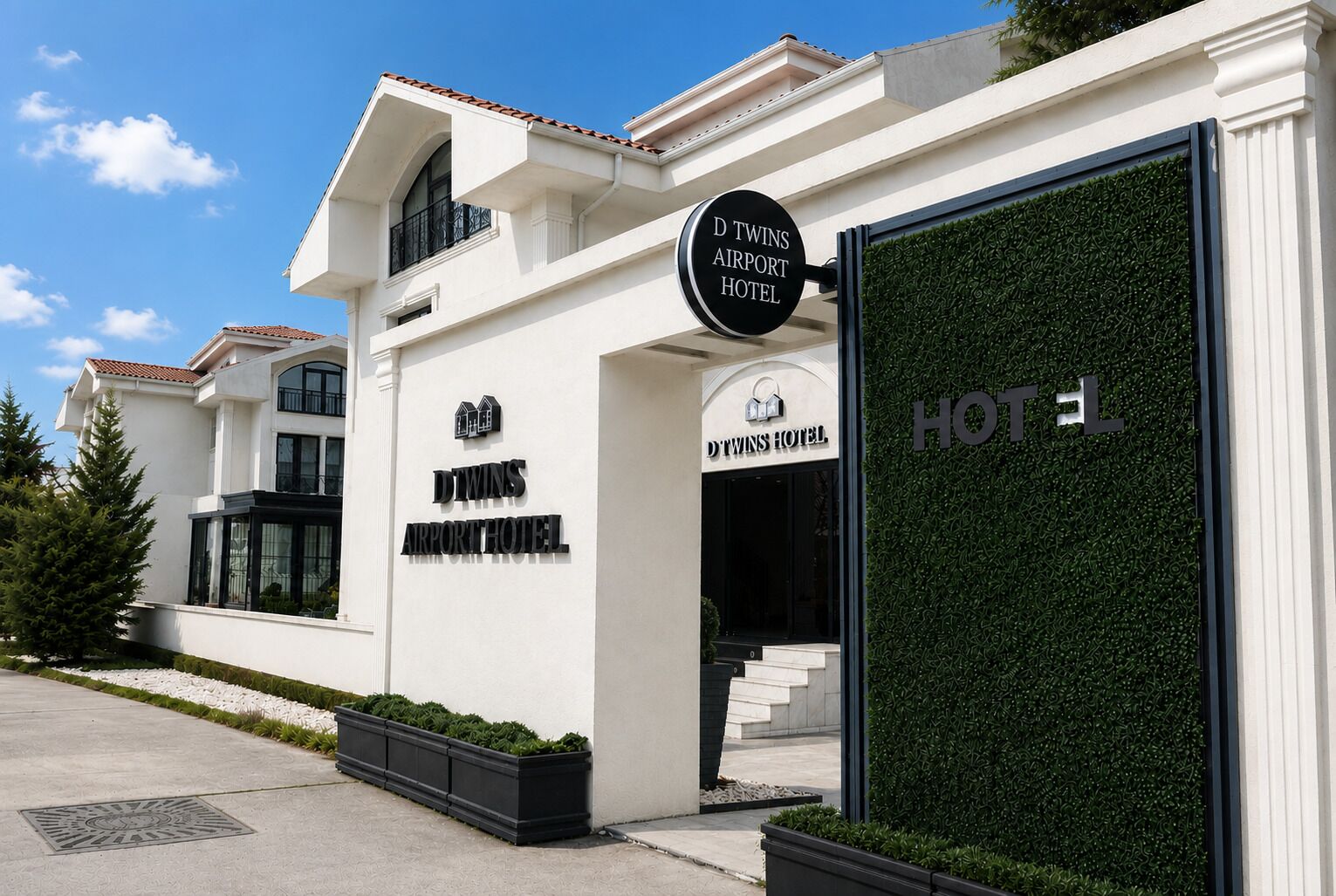 Un edificio moderno con un cartel que dice 'D Twins Airport Hotel' y una amplia entrada de cristal.