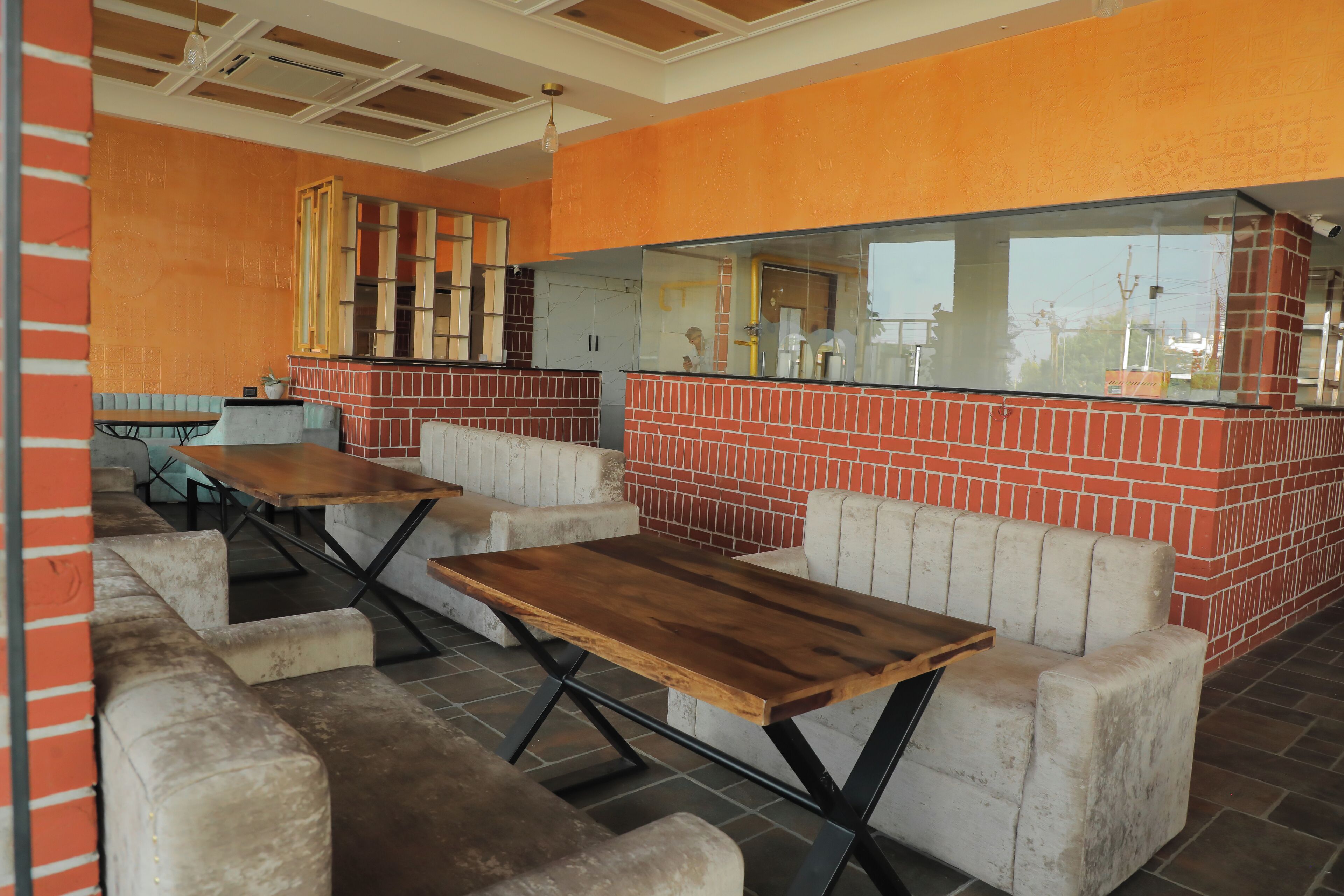 Un restaurant aux murs de briques, aux tables en bois et aux sièges rembourrés.