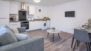A modern apartment with a kitchenette, a dining area, and a living room. - Harbour Nights Deluxe 7E by Interhome (Lossiemouth)