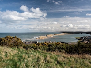 Eine Küstenstadt mit Meerblick, einem Sandstrand und einer Brücke zum Wasser.