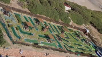 Vista aérea de un campo de golf con varias zonas verdes, senderos y estructuras de madera.