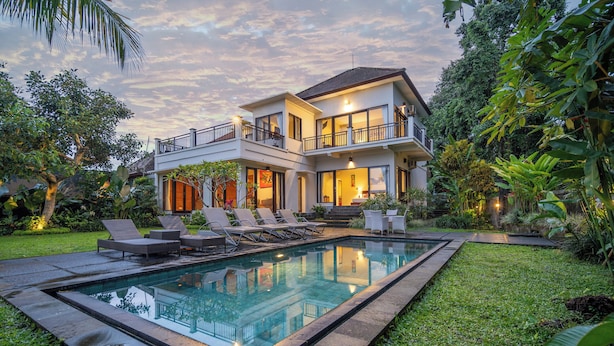 A two-story house with a swimming pool, outdoor seating, and lush greenery. - Mardika Private Villa Ubud (Ubud)