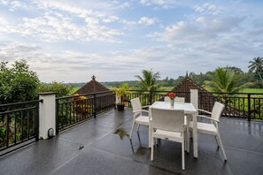 A covered outdoor area with a table and chairs, a small gazebo, and a view of a green landscape. - Mardika Private Villa Ubud (Ubud)