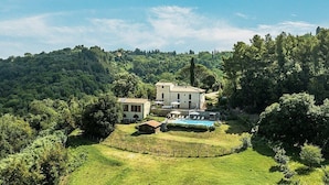 Une villa dotée d’une piscine, entourée d’une végétation luxuriante et de collines.