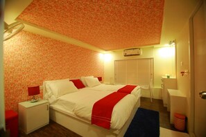 Cozy retreat with a single bed, floral-patterned ceiling, and a bedside table with a lamp.