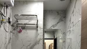 A compact bathroom with a toilet, sink, and shower. - Hotel Paris Plaza (Ahmedabad)