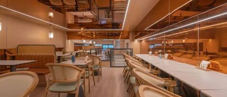 A modern restaurant with multiple dining areas, wooden furniture, and pendant lighting.