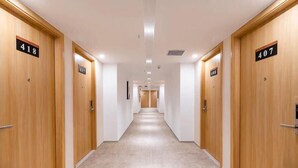 Un pasillo de hotel con puertas de madera numeradas 418 y 407.