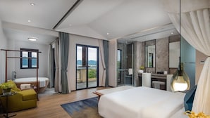 A modern hotel room with a large bed, a desk, a bathroom with a bathtub, and a balcony with a view. - Huizhou Hazens East Resort (Huizhou)