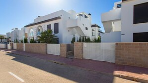 A modern residential building with a white facade, multiple balconies, and a gated entrance. - CH Enora Garden Doña Pepa (Ciudad Quesada) (Ciudad Quesada)