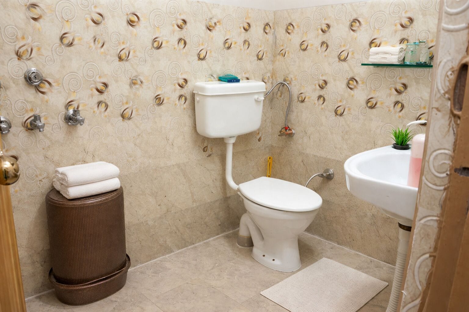 Un baño con inodoro, lavamanos y azulejos decorativos.