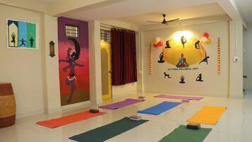 A yoga studio with mats, a mural, and wellness symbols on the wall.