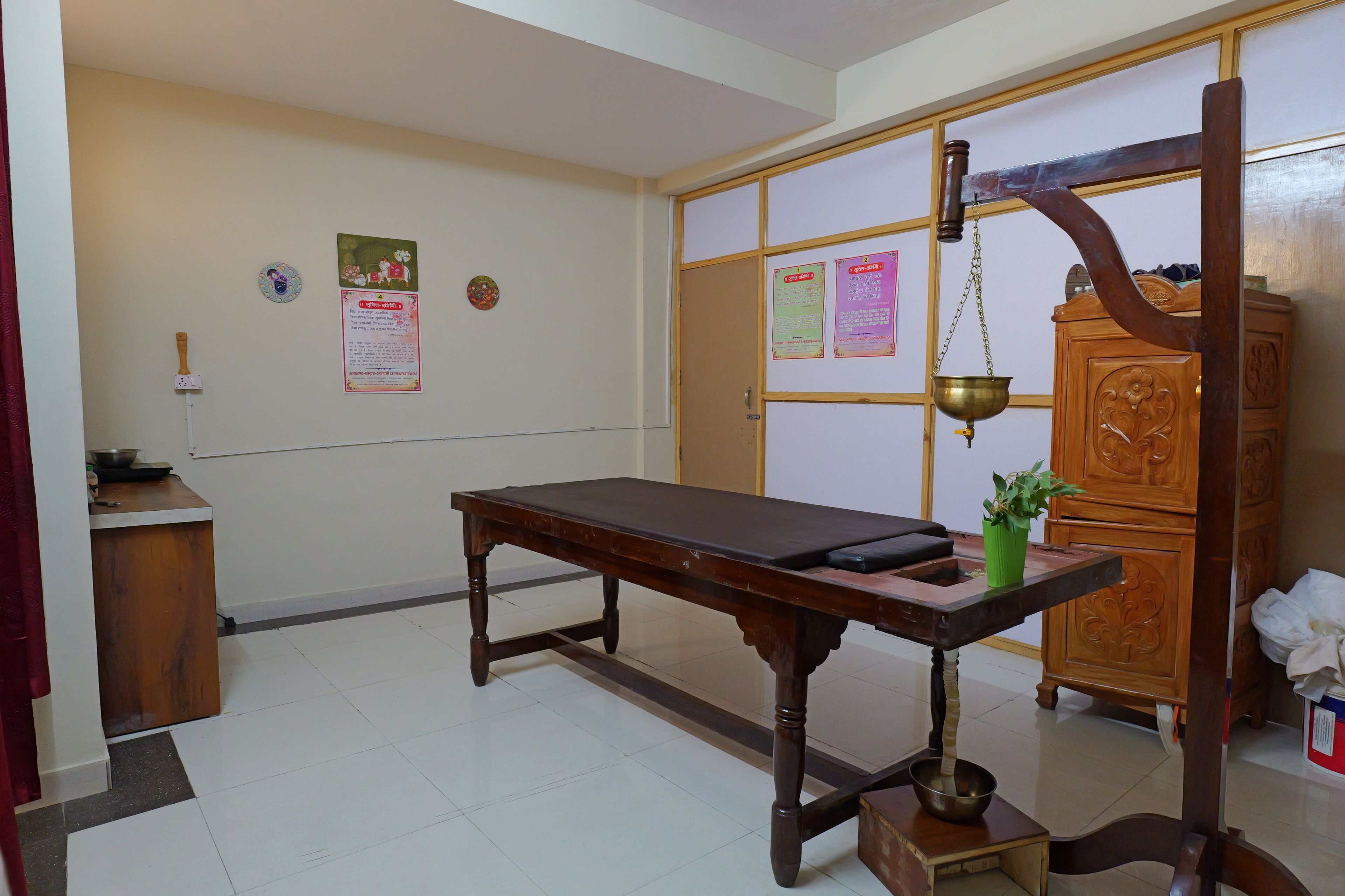 A room with a wooden table, a cabinet, and a traditional scale.