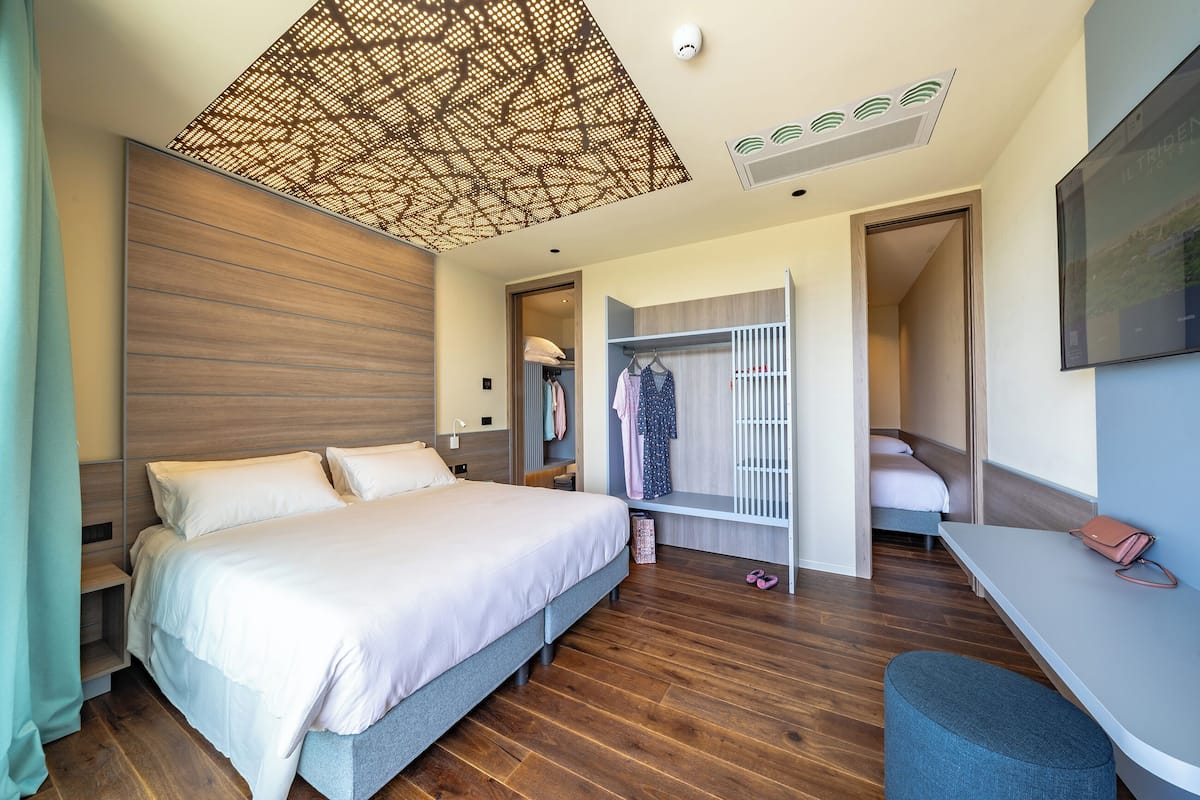 Un dormitorio moderno con una cama grande, un armario, un escritorio y un closet.