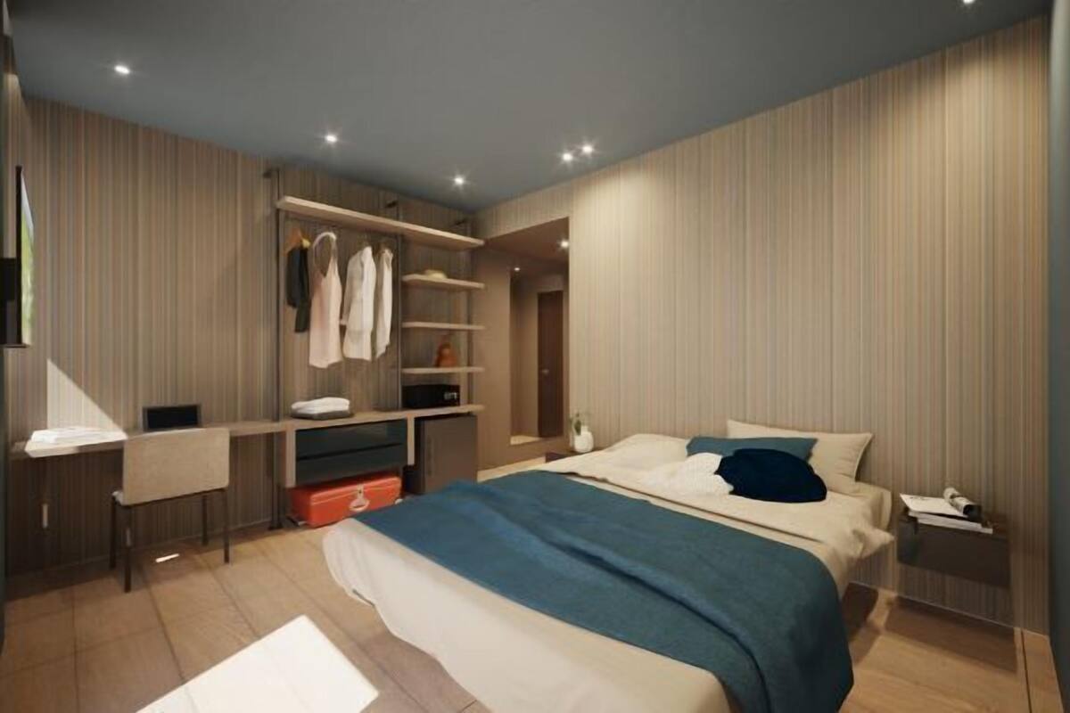 Un dormitorio moderno con una cama grande, un armario empotrado y una mesita de noche.