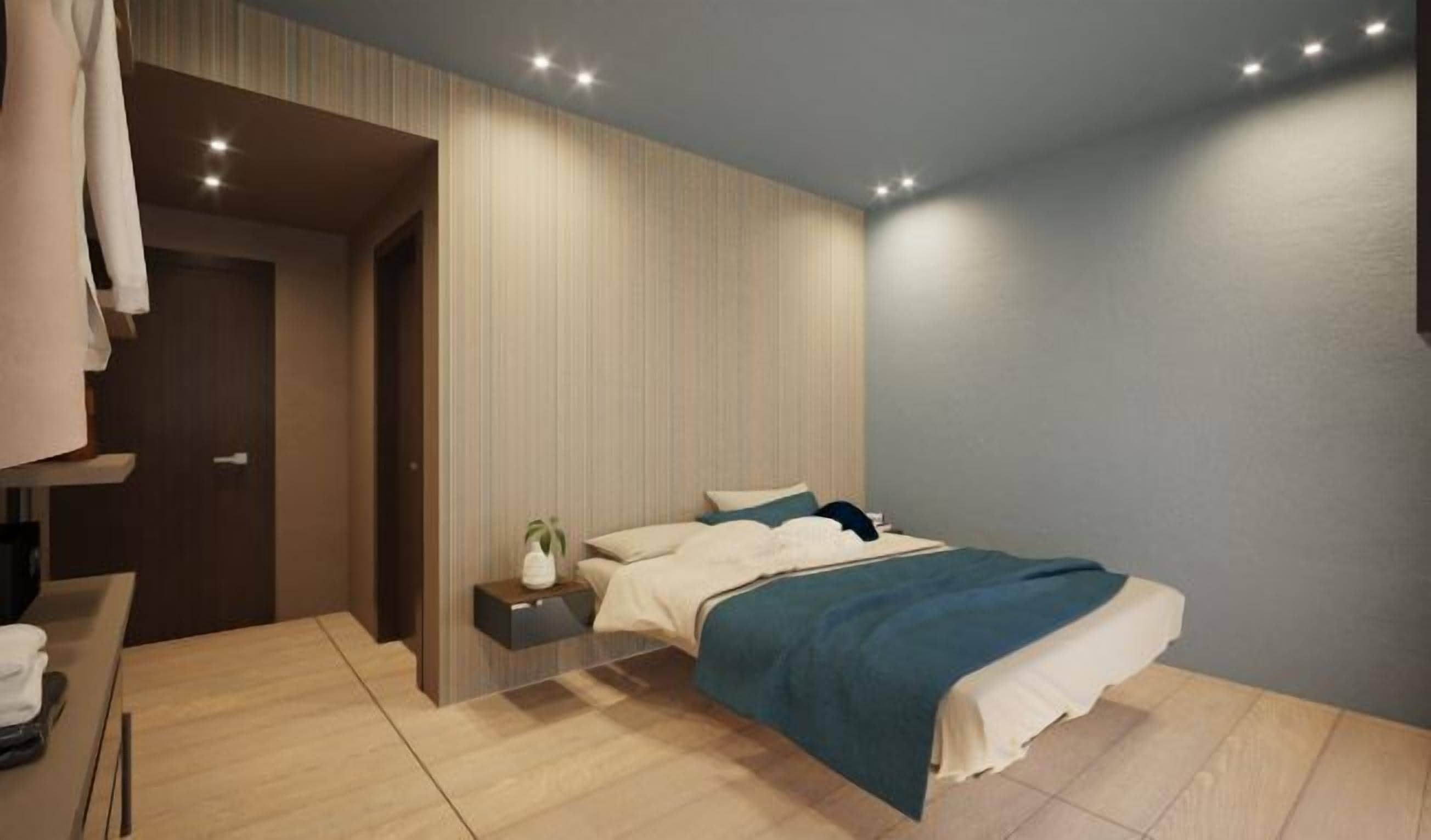 A modern bedroom with a bed, bedside table, and a small plant.