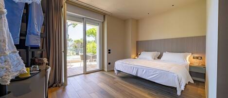 A bedroom with a bed, a nightstand, a lamp, a sliding glass door leading to an outdoor area, and a view of the outdoors.