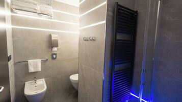 Ein modernes Badezimmer mit einer Bio-Toilette, einem Handtuchhalter und einer beheizbaren Handtuchstange.
