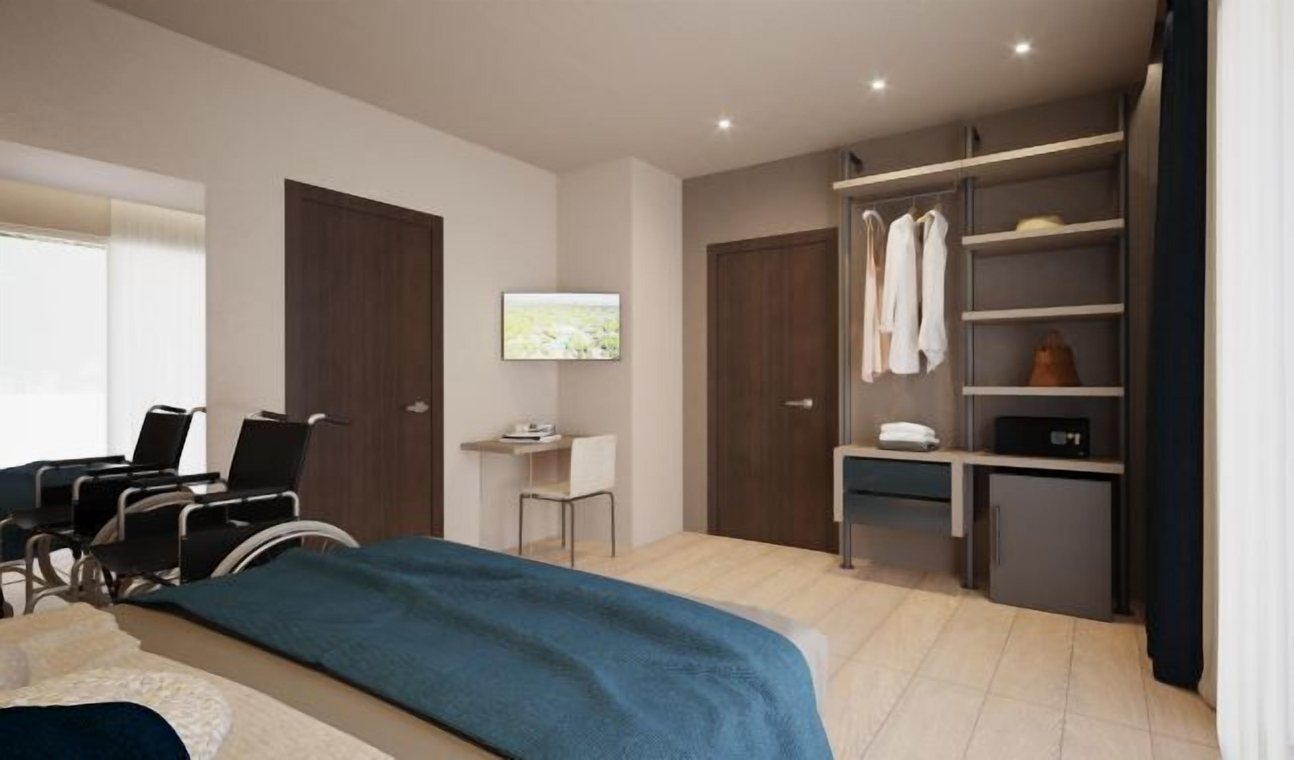 Ein modernes Hotelzimmer mit Bett, Schreibtisch, Stuhl, Kleiderschrank und Fernseher.