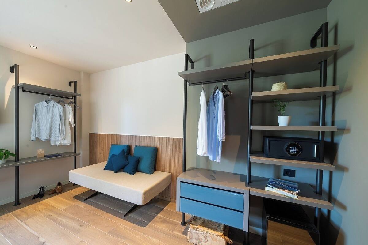 Un dormitorio moderno con cama, estanterías empotradas y un escritorio.