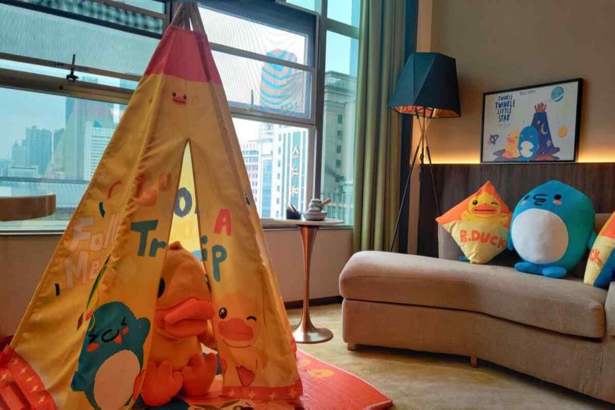 Una habitación acogedora con una carpa de juegos de colores, juguetes suaves y un cuadro en la pared.