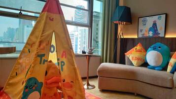 Una habitación acogedora con una carpa de juegos de colores, juguetes suaves y un cuadro en la pared.
