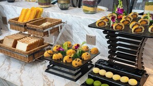 A buffet with various food items including bread, pastries, and colorful spherical desserts. - Chengdu Hazens Hotel (Chengdu)