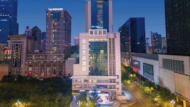 A modern hotel with a prominent tower and signage in a cityscape at dusk. - Chengdu Hazens Hotel (Chengdu)