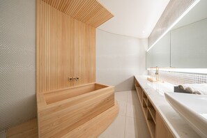 A modern bathroom with a wooden bathtub, white marble countertop, and a large mirror. - Guwol Hotel Rondo (Incheon)