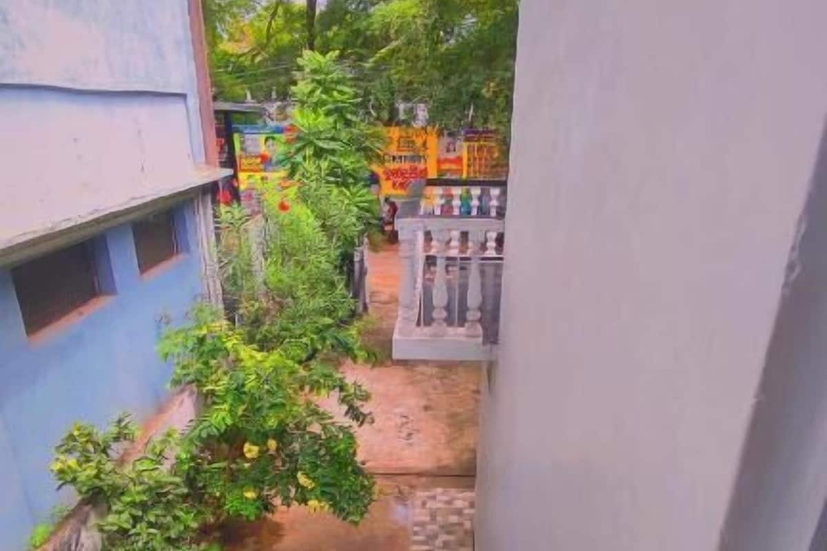 Un escalier étroit mène à une cour intérieure agrémentée d’une petite fontaine et de quelques plantes.