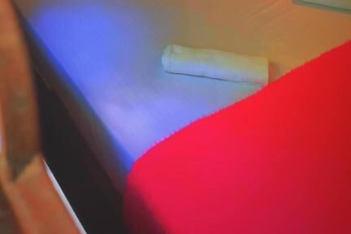 Une chambre d’hôtel avec un lit, des oreillers, une table de chevet et une lampe.