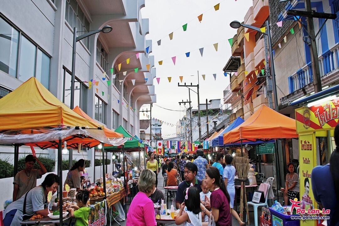 Un marché de rue animé, avec de nombreux étals et beaucoup de monde.