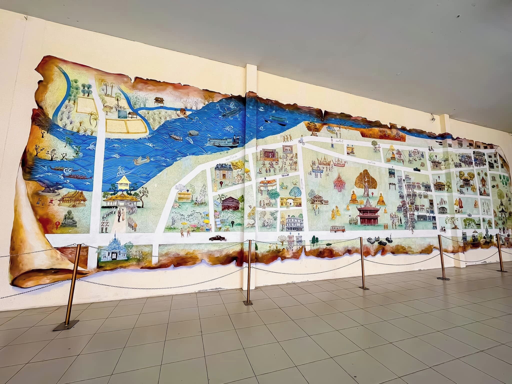 A large, detailed mural on a wall, featuring various scenes and structures.