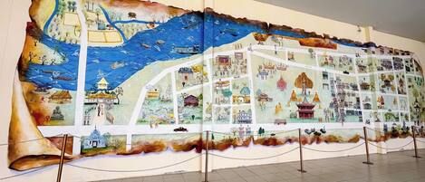 A large, detailed mural on a wall, featuring various scenes and structures.