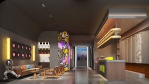 Un moderno vestíbulo de hotel con mostrador de recepción, zona de estar y vistas a la ciudad.