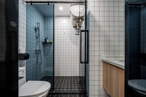 Ein Badezimmer mit Dusche, Toilette und Waschbecken.