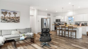 Un salon moderne avec un canapé, un fauteuil en cuir noir et une table basse.