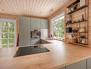 Een koelkast, een vaatwasser, kookgerei, borden en bestek