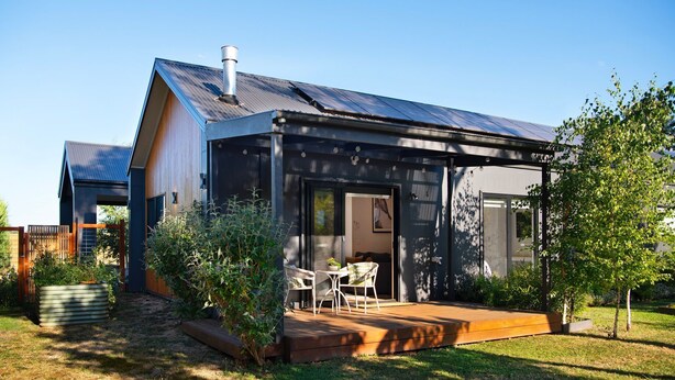 A modern house with a covered patio, a chimney, and a garden with a wooden deck and outdoor furniture. - Cosy Edge Studio-Modern stuido, quiet and walking distance to Farmers Arms Hotel (Daylesford)