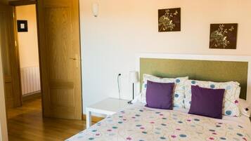 Un dormitorio con una cama, una mesita de noche y una puerta.