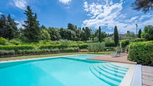 A rectangular swimming pool with a clear blue water, surrounded by well-maintained greenery and a brick patio area with two lounge chairs. - Casa Viola Pool, Wifi, Montaione (Montaione)