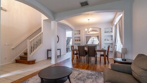 A spacious living room with a staircase, a dining area with a chandelier, and a cozy seating area. - Ultimate Family Retreat with Themed Rooms, Private pool and spa, theater & games! Pet Friendly (Kissimmee)