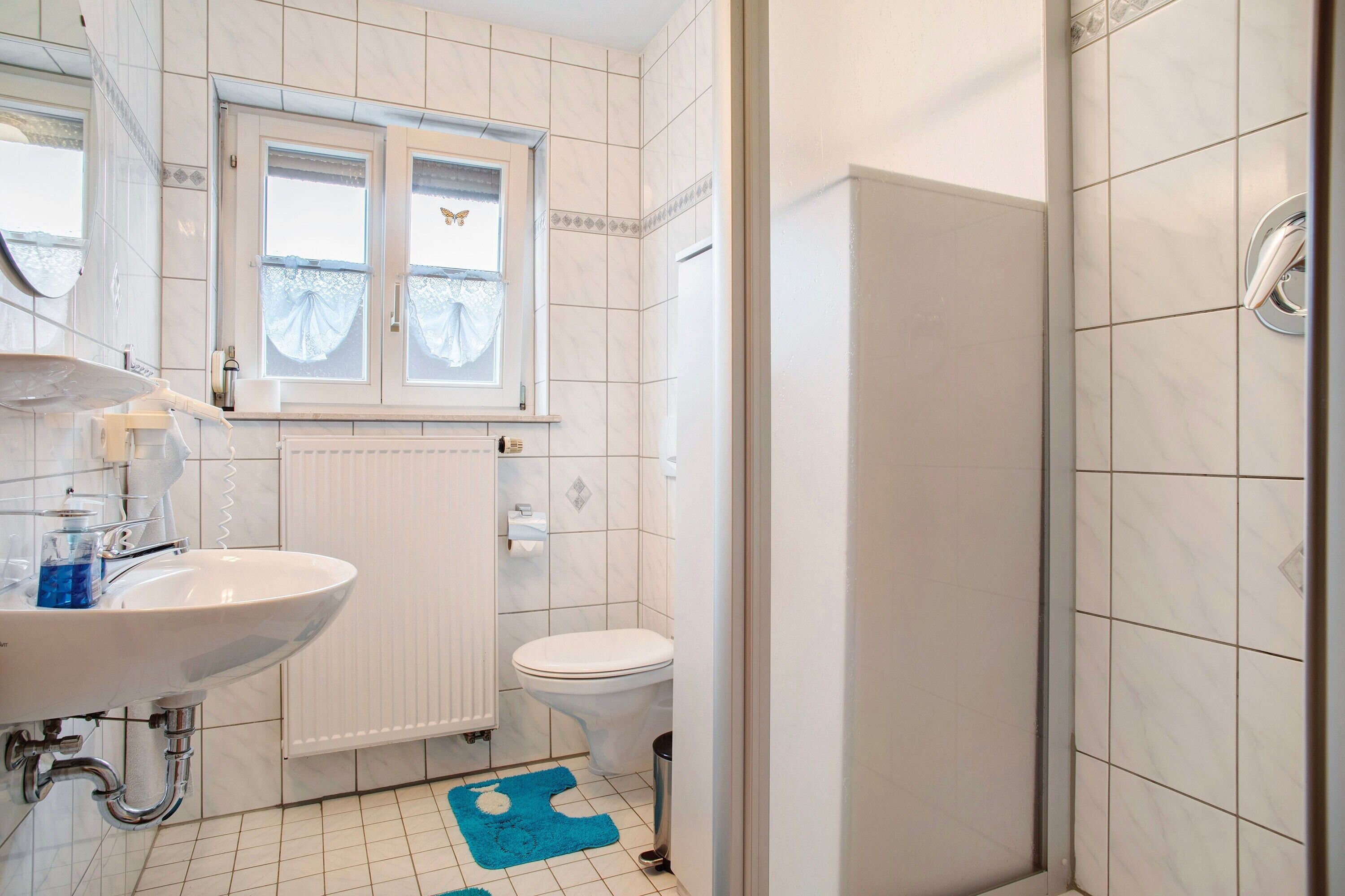 Une salle de bain avec un lavabo, des toilettes et une douche.