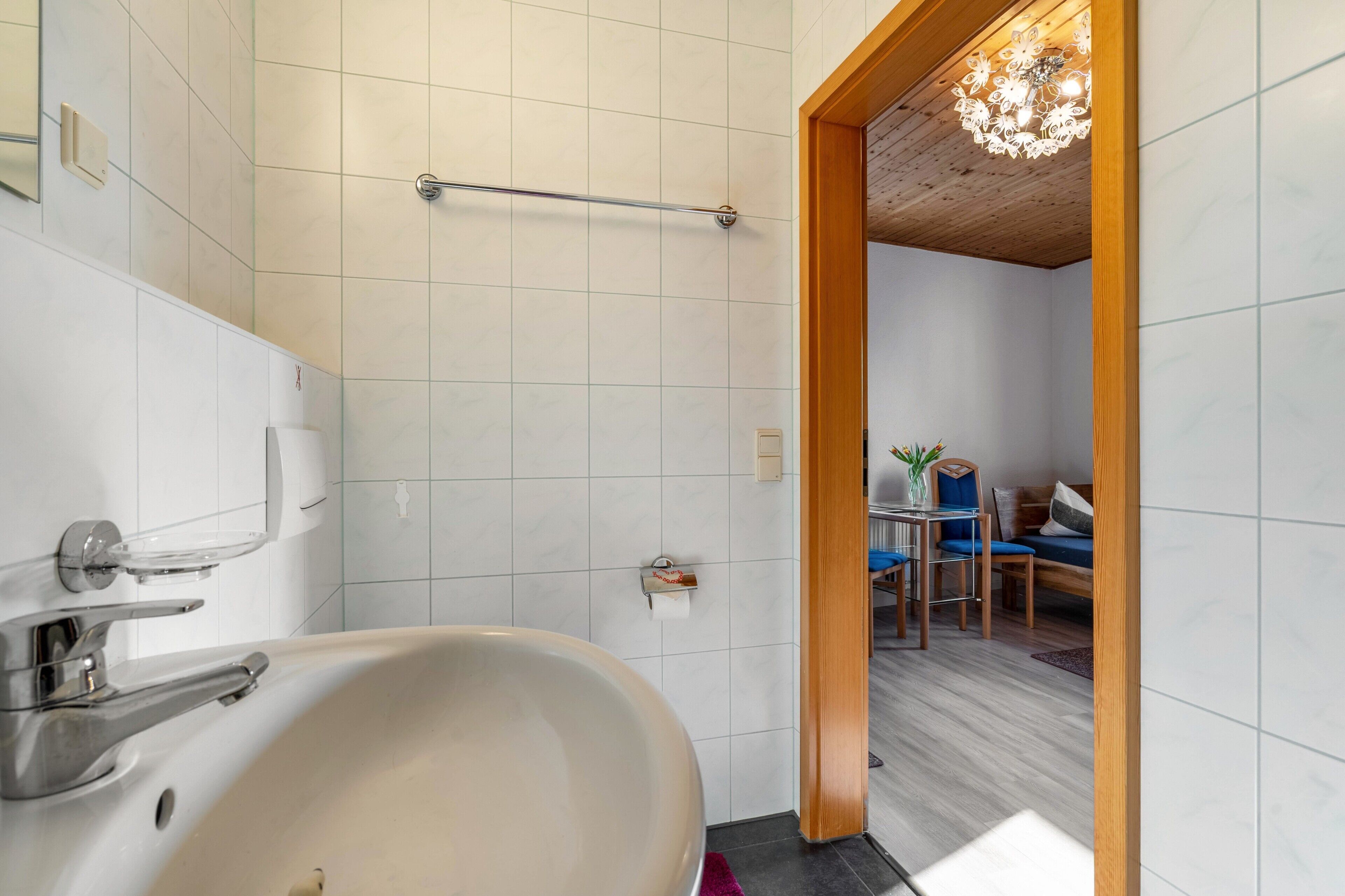 A bathroom with a bathtub, a towel rack, and a shower head.