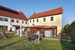 Ein Wohngebäude mit rotem Ziegeldach, einer Garage und einer Satellitenschüssel.