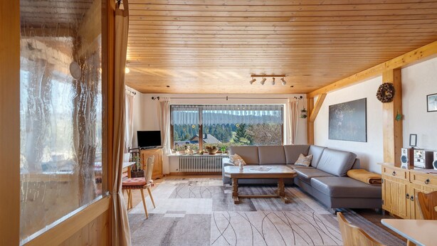 A cozy living room with a sofa, coffee table, and TV.